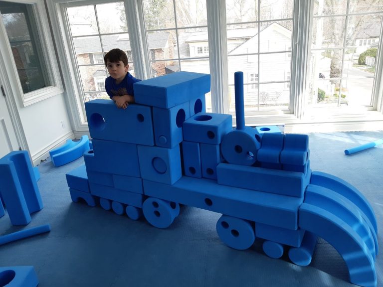 A child building with a combination of Medium and Big Blue Blocks from the Mixed Blue Block Sets collection.