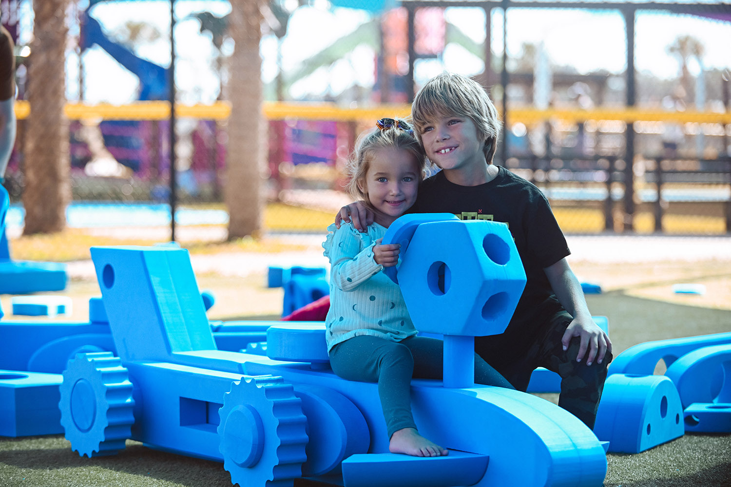 children playing with blue block transportation set