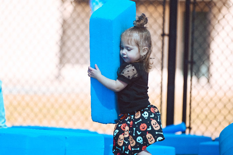 child carrying a big blue blocks