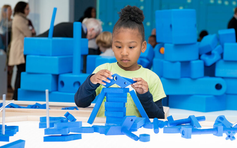 Child building with small foam building blocks.